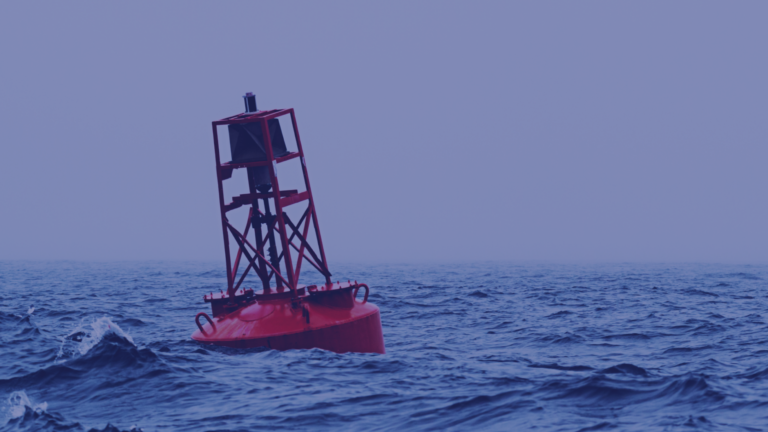 An image of a red buoy floating on a stormy sea.